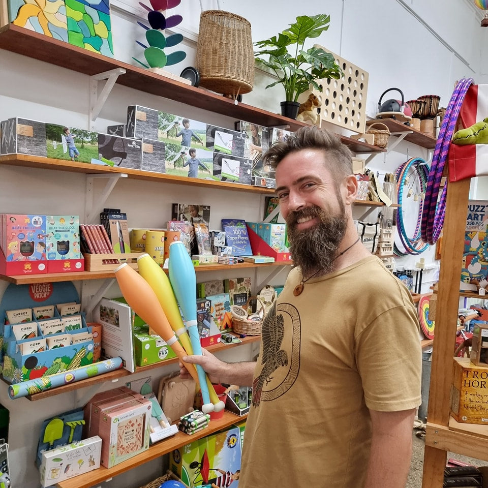 Brad from Earth Toys holding PX3 Sirus Juggling Clubs Pastel Orange, yellow, blue in-store